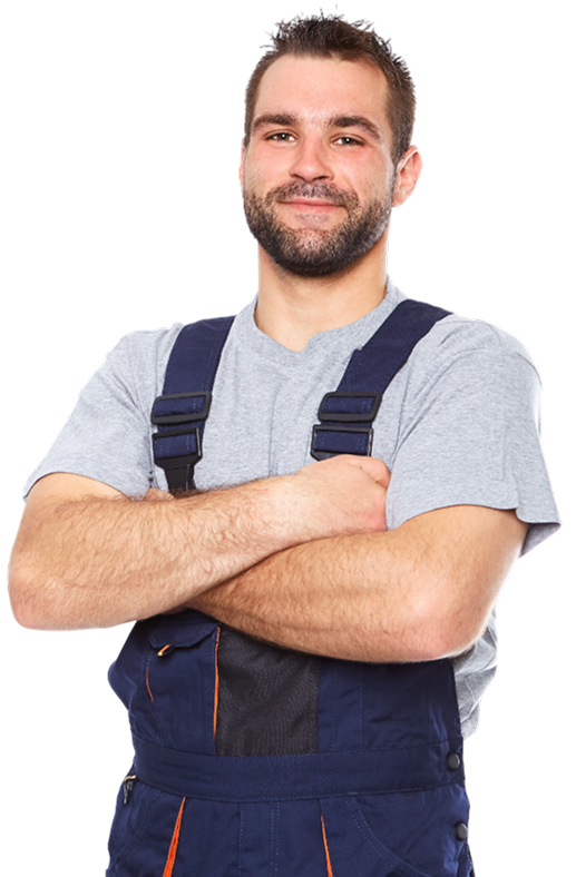 Man wearing a gray t-shirt and blue overalls with crossed arms, smiling at the camera.